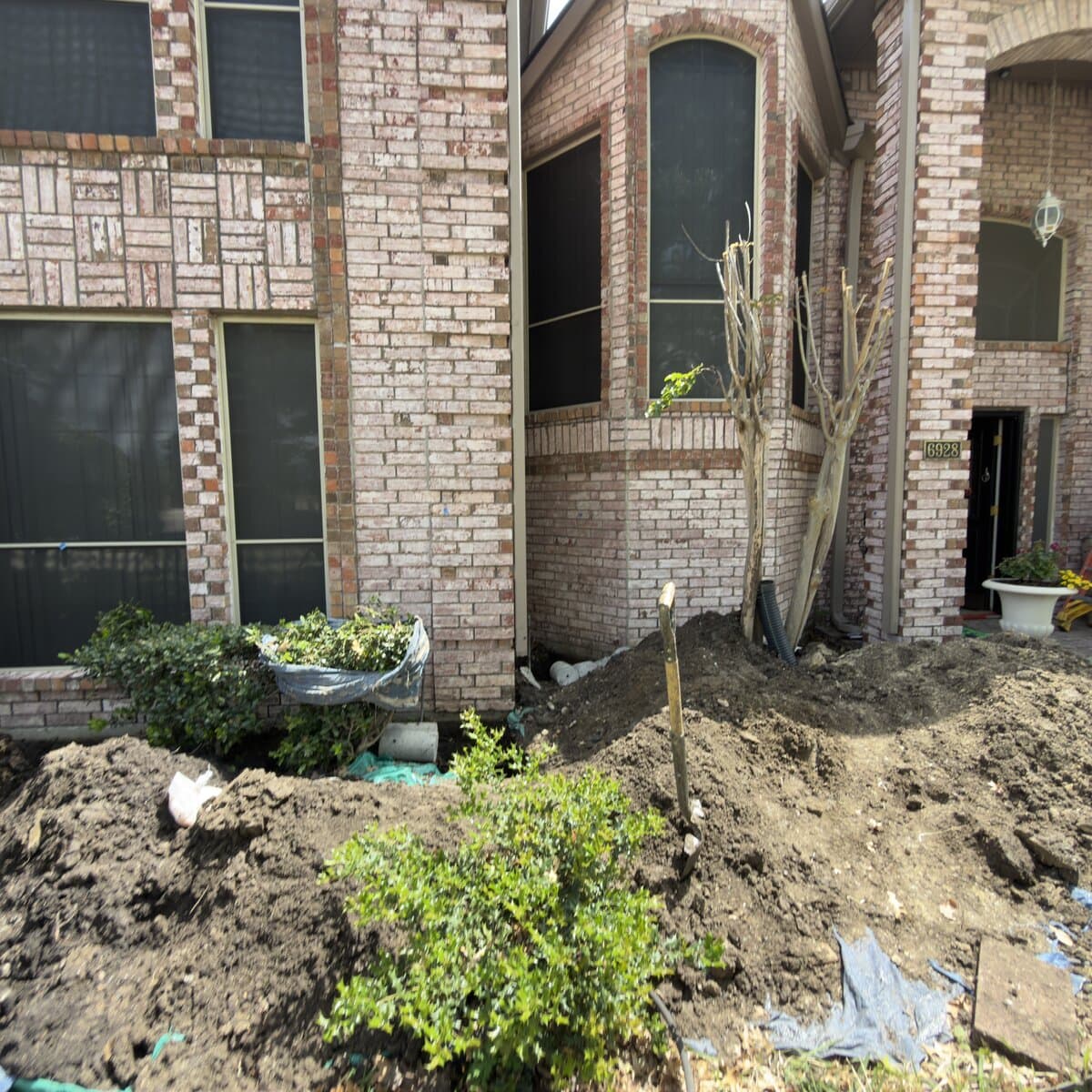 Active foundation repair work on a two-story DFW home