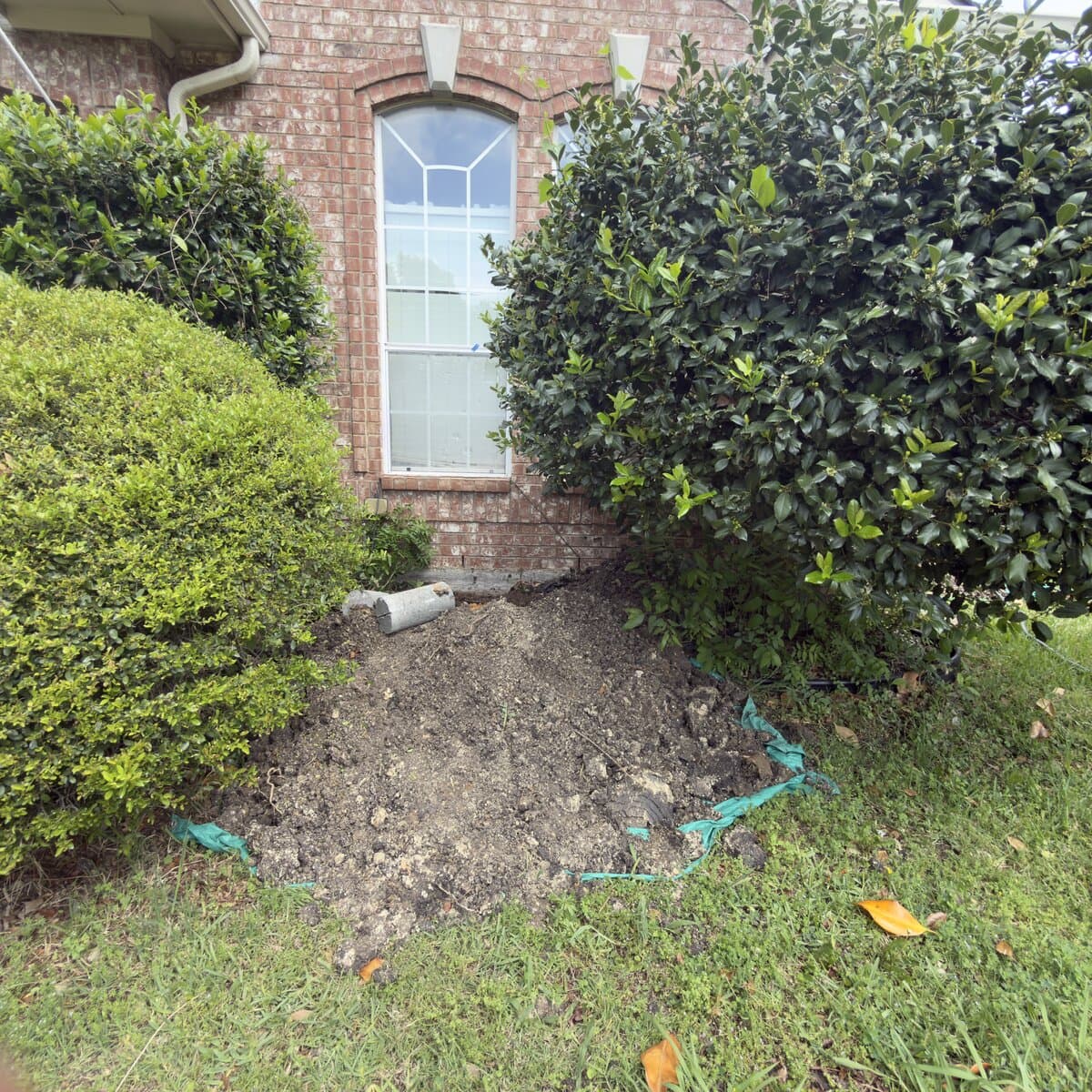 Stratum foundation excavation beside a DFW brick home