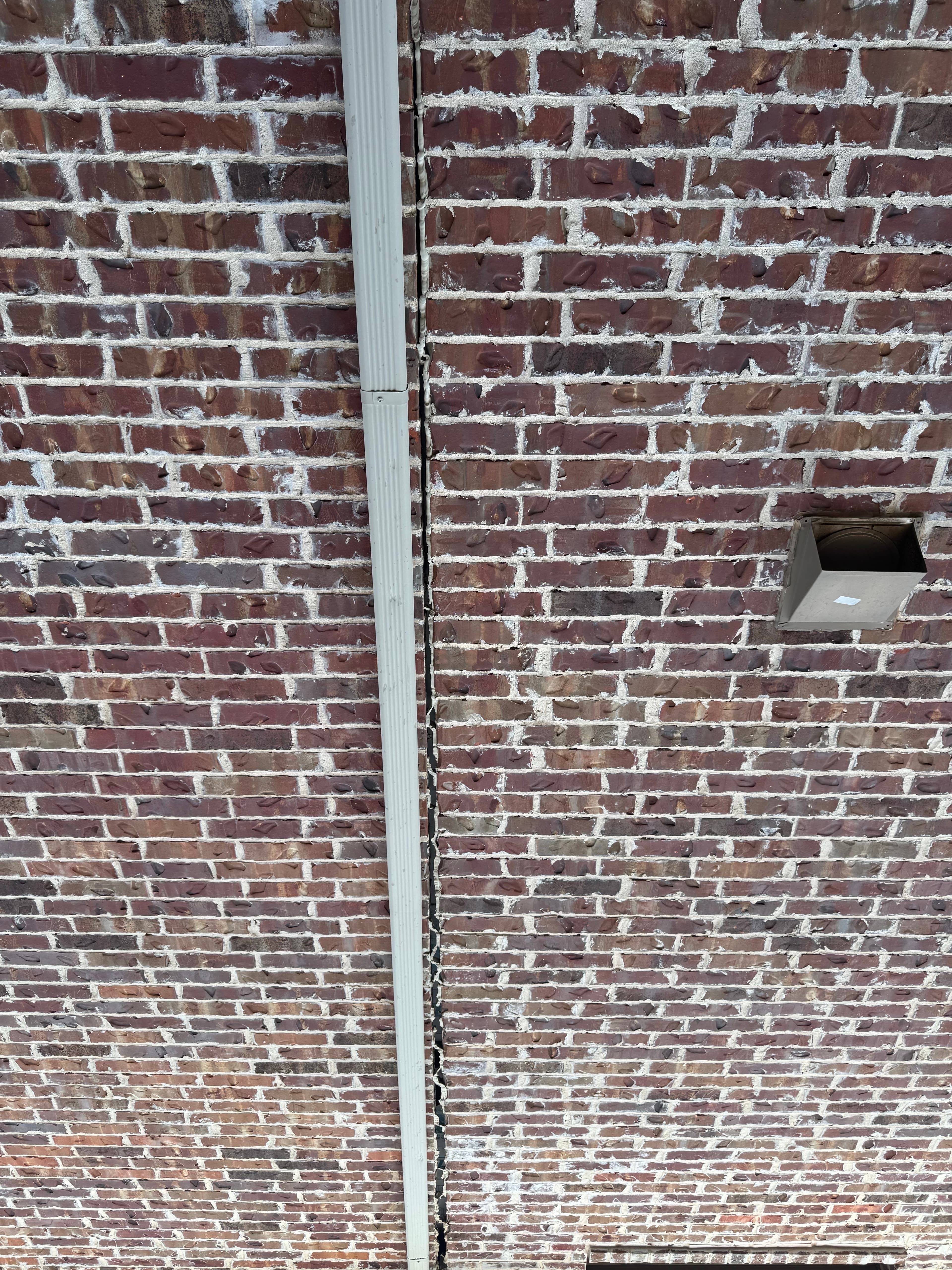 Vertical settlement crack running up a brick wall in North Texas