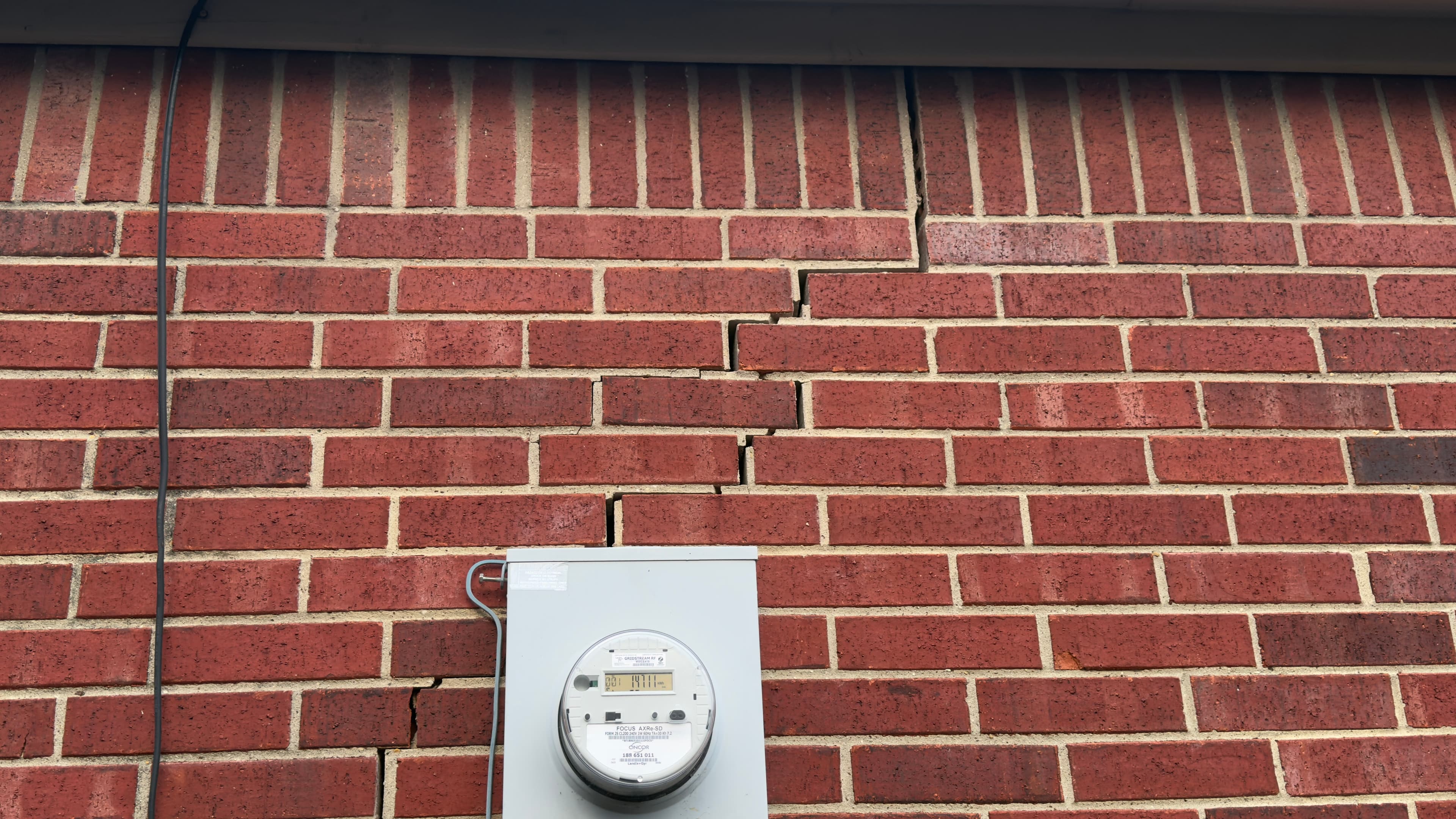 Stair-step brick mortar crack indicating foundation settlement on a DFW home