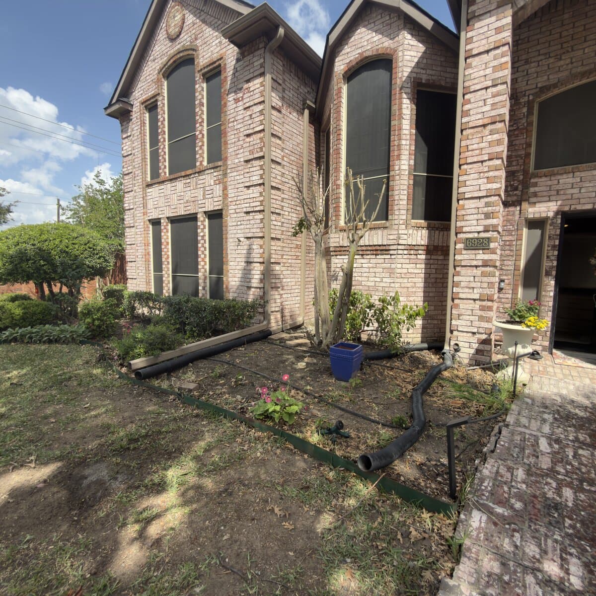 Two-story brick home with completed foundation work backfilled